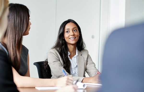 Frau sitzt in einem Meeting und lächelt