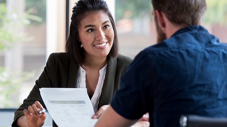 A smiling businesswoman welcomes a potential freelancer for her project for an interview.