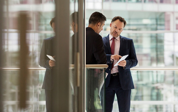 Two men in suits have a discussion.