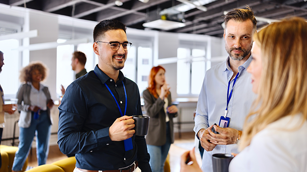 Junge Mitarbeitende unterhalten sich auf einem Networking-Event