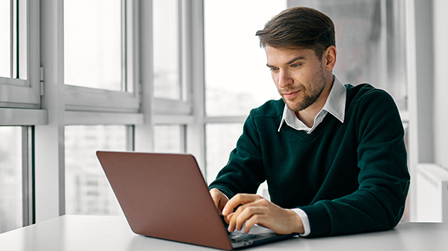 Mitarbeitender sitzt vorm Laptop