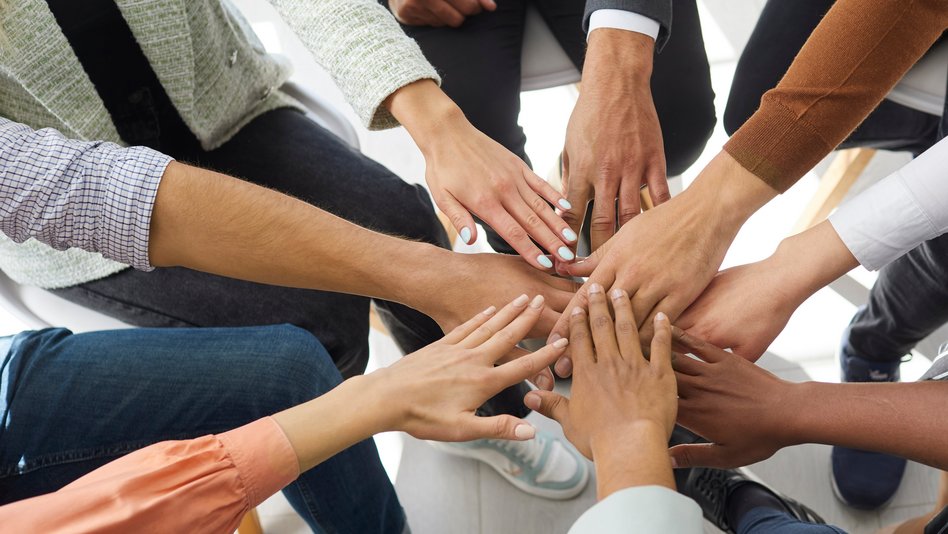 Viele Personen stecken die Hände zusammen