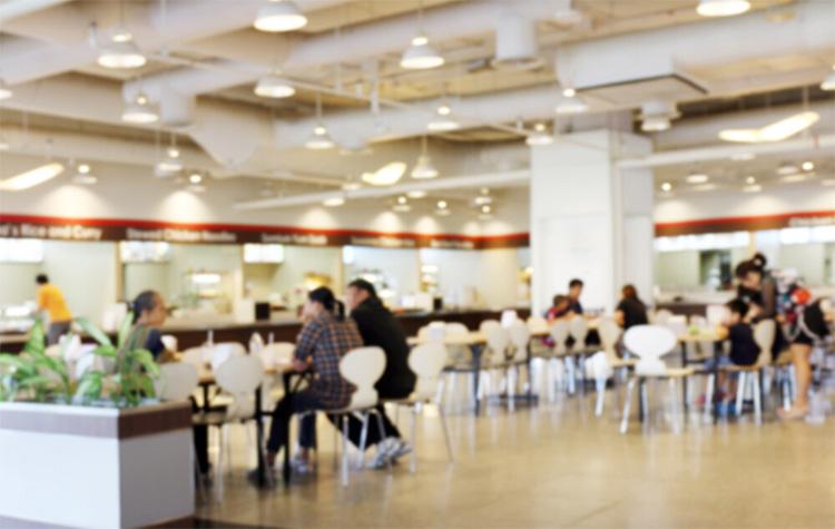 Arbeitnehmende sitzen in einer Cafeteria